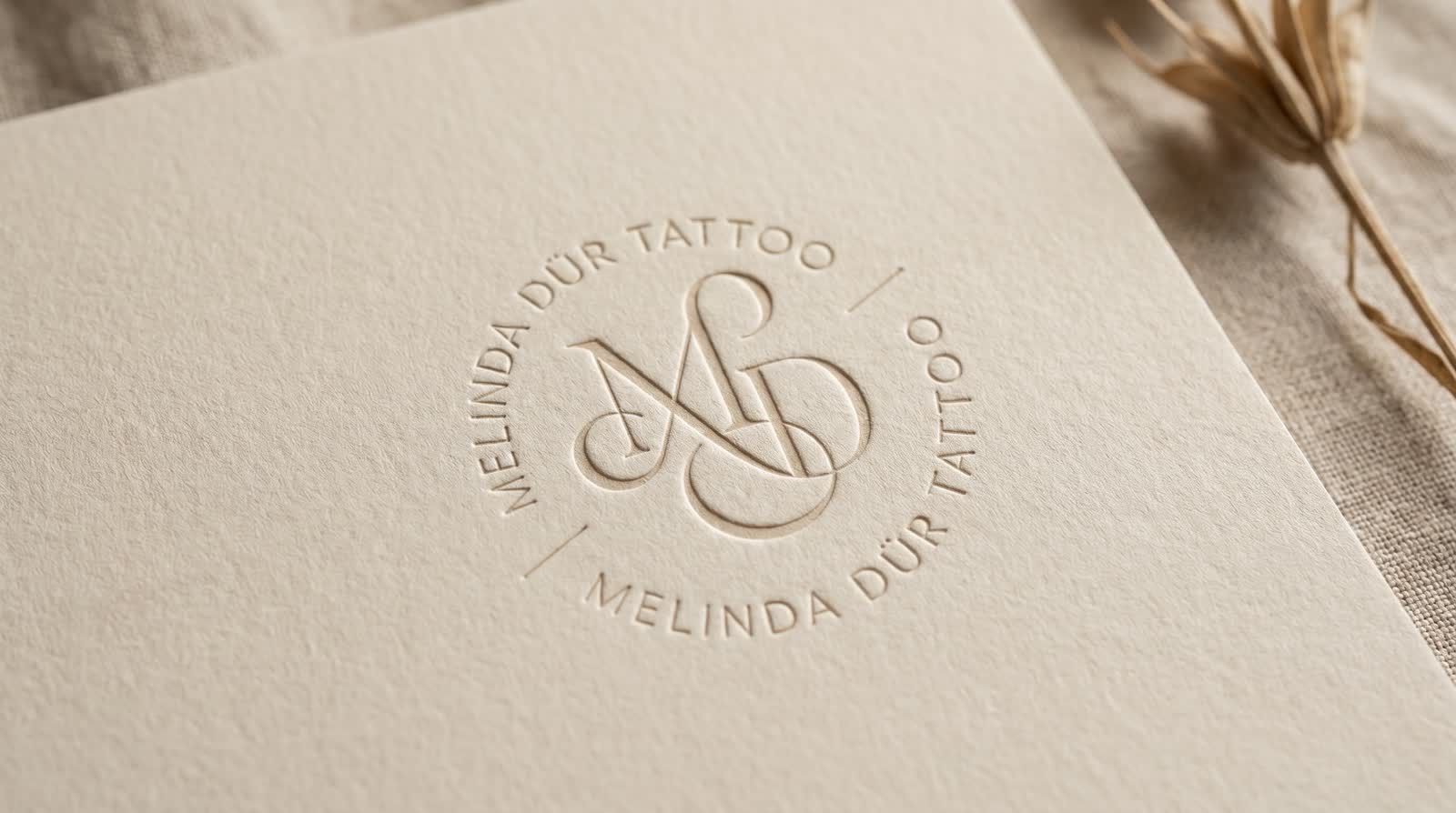 In Büttenpapier geprägtes Melinda-Dür-Tattoo-Logo